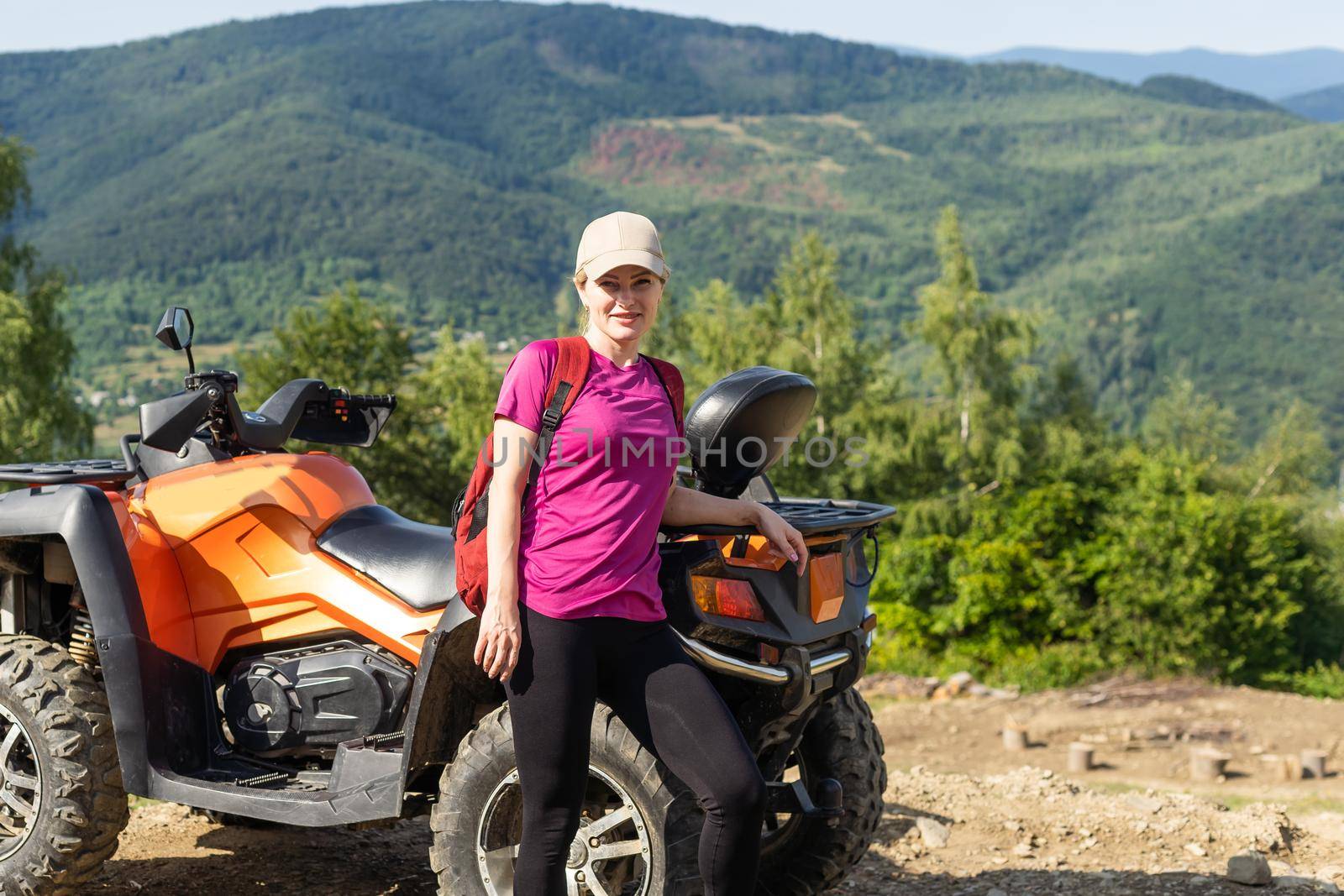 Young woman on quad bike on a trail. Young woman driving all terrain vehicle in nature on a sunny day.
