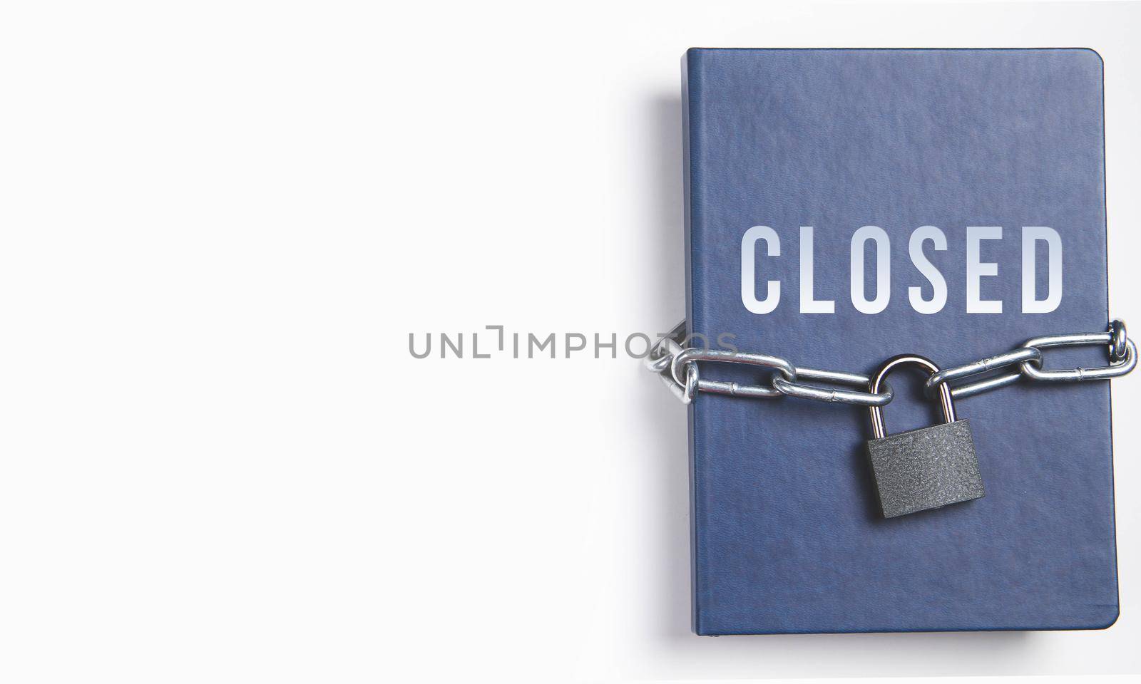 The book is locked under lock and key on a white background. Secret archive. Chain on the book close-up. The book of secrets is under lock and key.