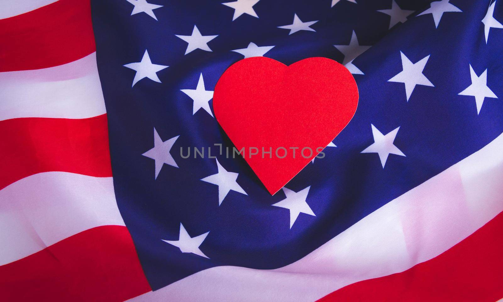 Love for America. Heart on the background of the USA flag. Patriotism and love. The heart of the country.