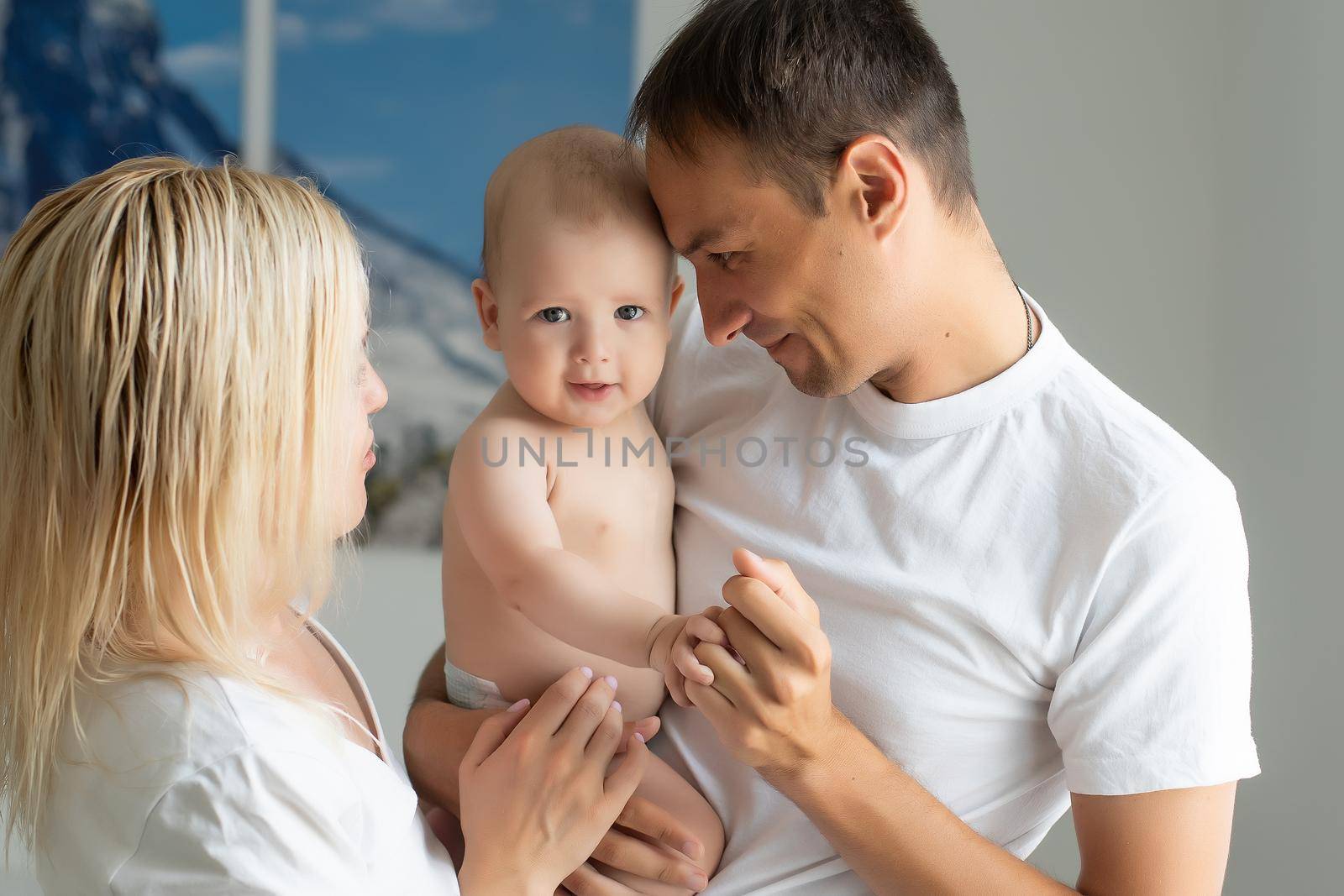 A Happy young family with baby in white bedroom by Andelov13