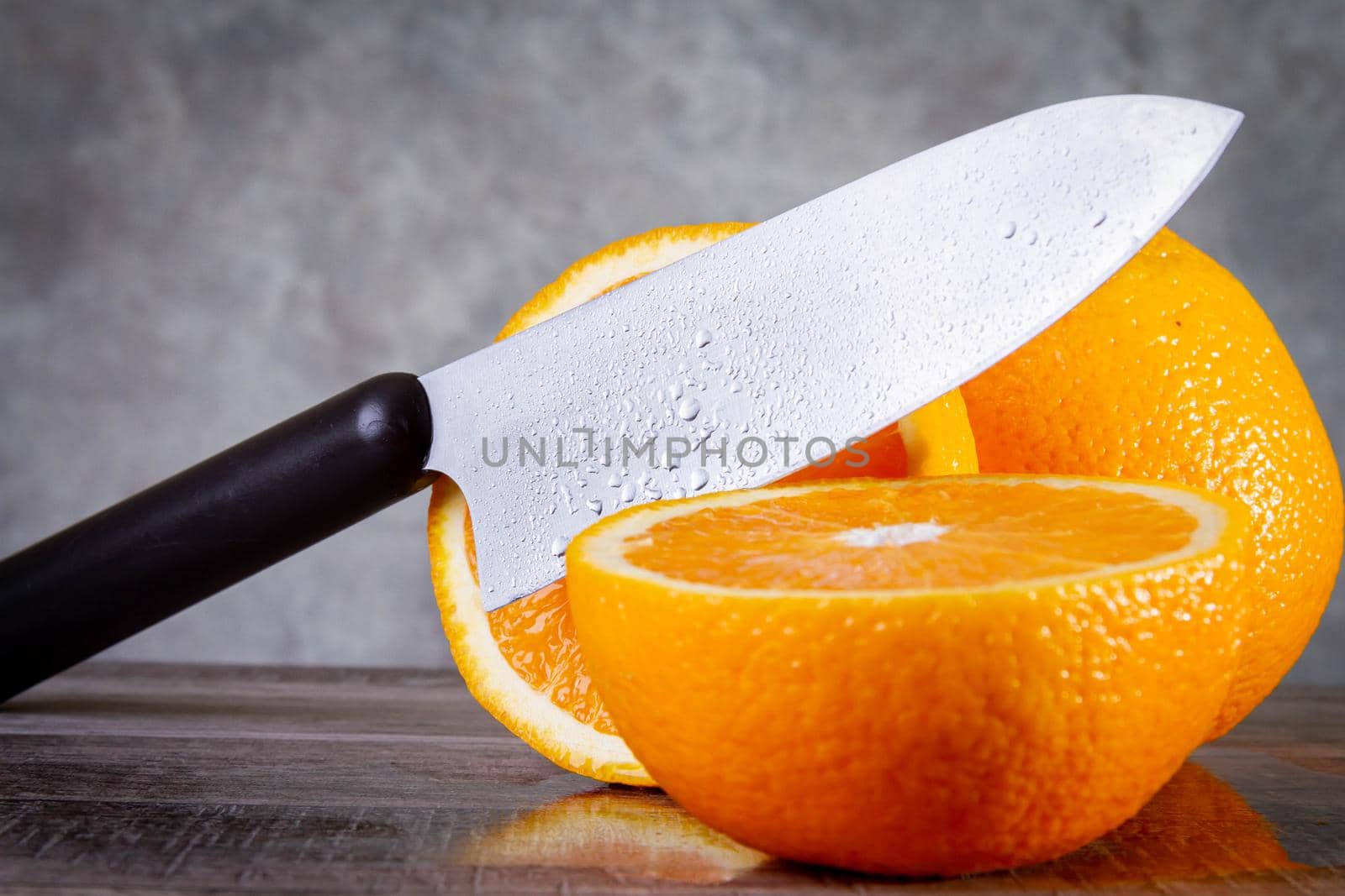 Slicing oranges side view. A man cuts an orange with a knife. The process of making juice from fruits. Knife and orange.