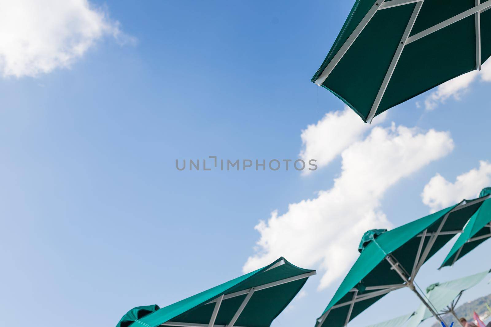 Sun blue and white open umbrella, comfortable rest by the ocean with personal beach parasol on beautiful cote dazur coastline, safe tan accessory, sunstroke protection