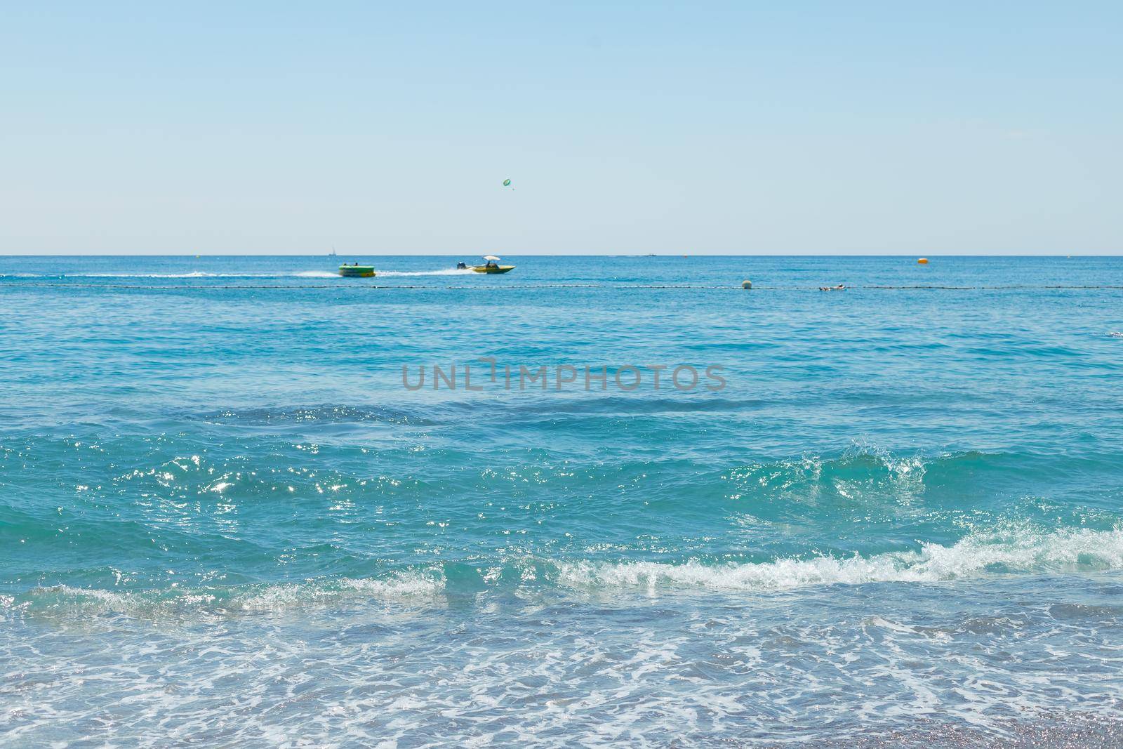 Soft wave of the turquoise sea on the sandy beach. Natural summer background with copy space