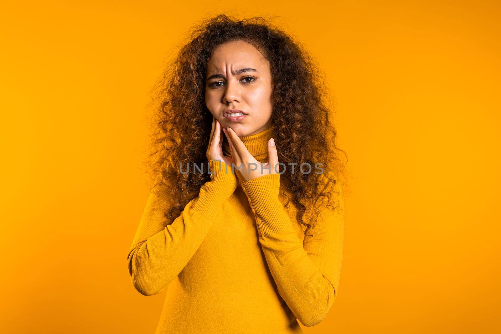 Young pretty woman with tooth pain on yellow studio background. Toothache, dental problems, stomatology and medicine concept by kristina_kokhanova