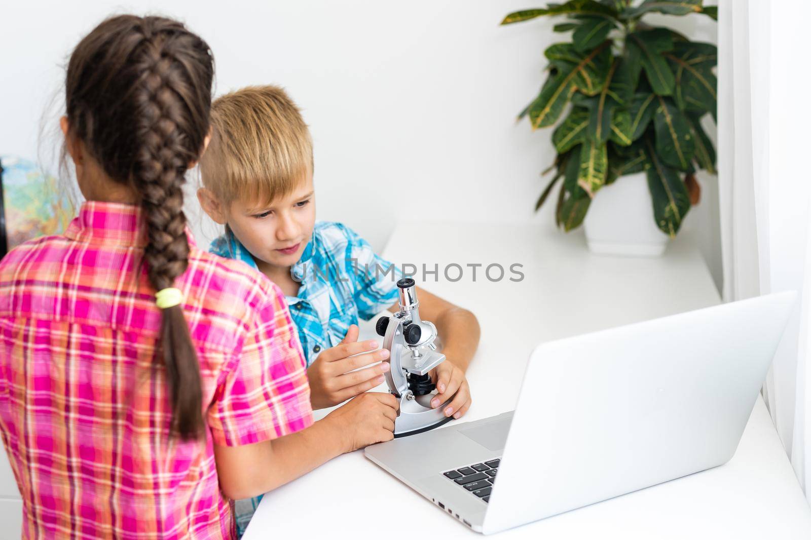 renewable energy, children, technology, science and people concept - kids or friends with laptop computer and microscope model.