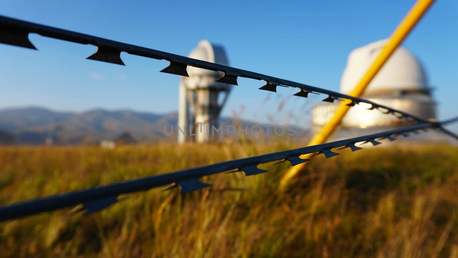 A large observatory is protected by a barbed fence by Passcal