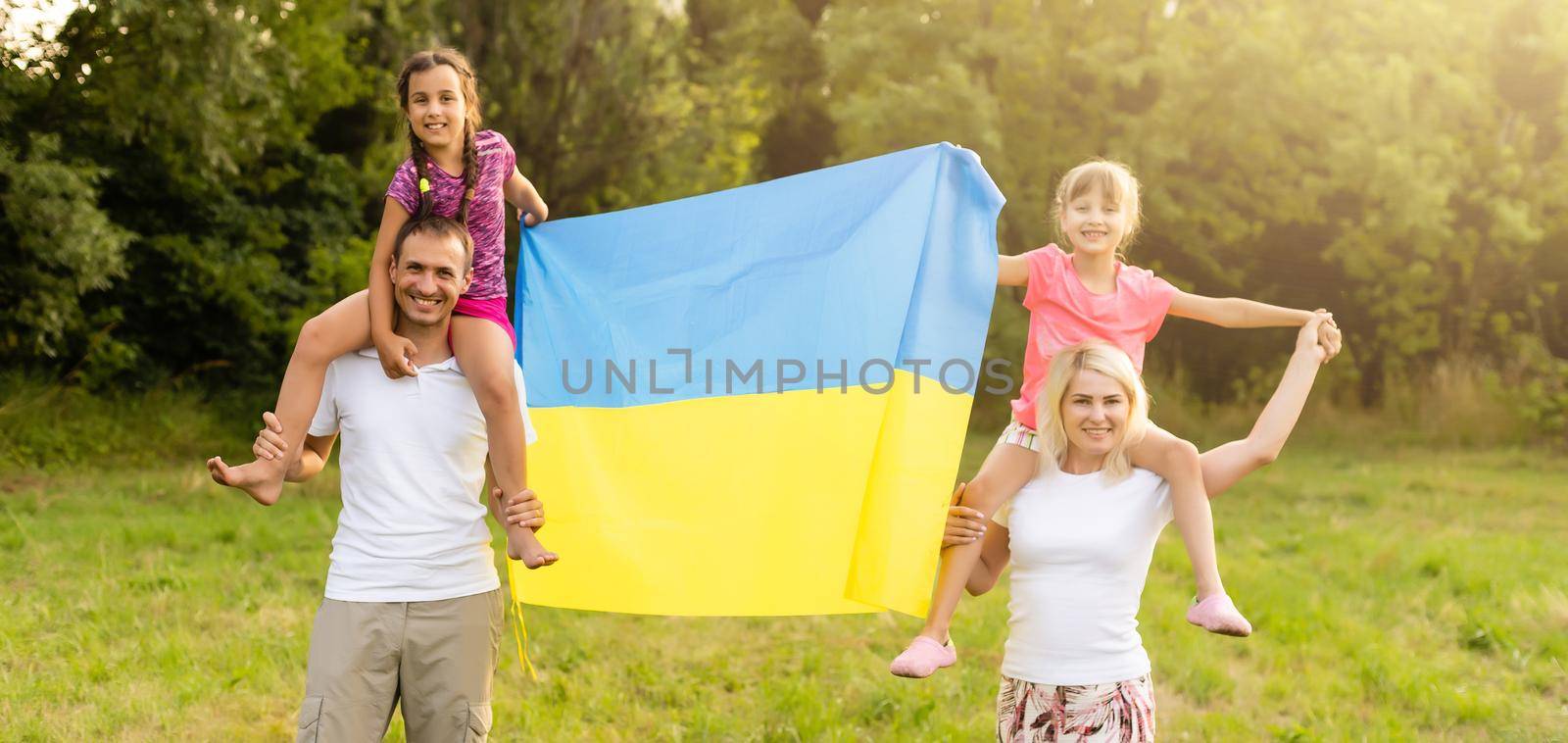 Flag Ukraine in hands of little girl in field. Child carries fluttering blue and yellow flag of Ukraine against background field