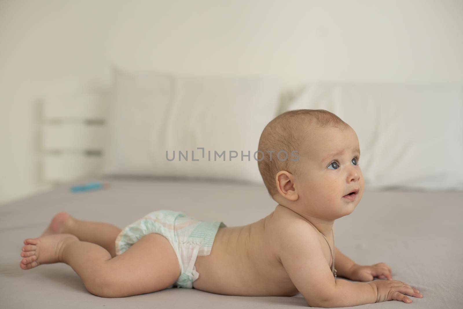 Portrait of a crawling baby on the bed in her room.