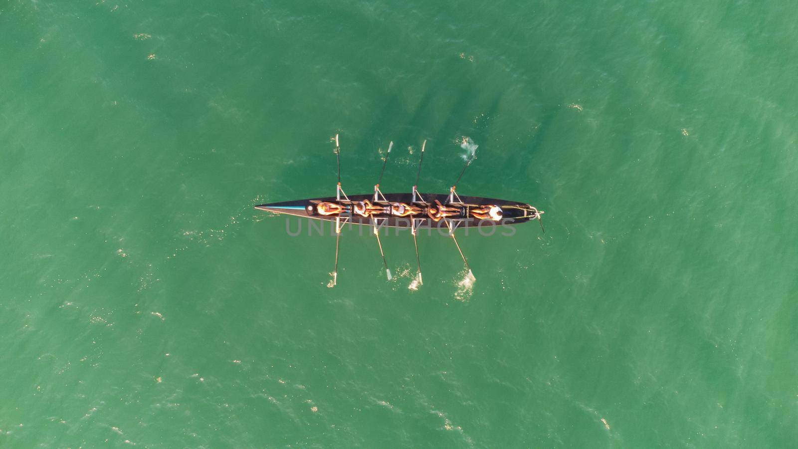 rowing team paddles on the tranquil sea by senkaya