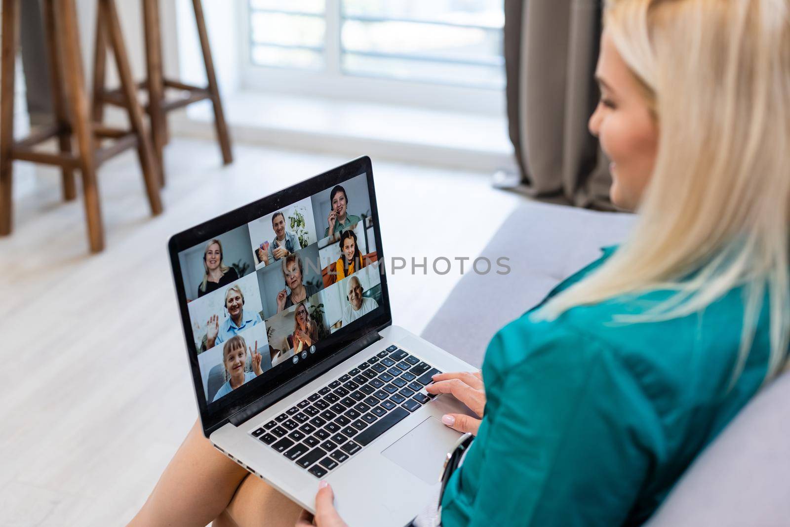 Cropped image of young woman using laptop for video conference at home.