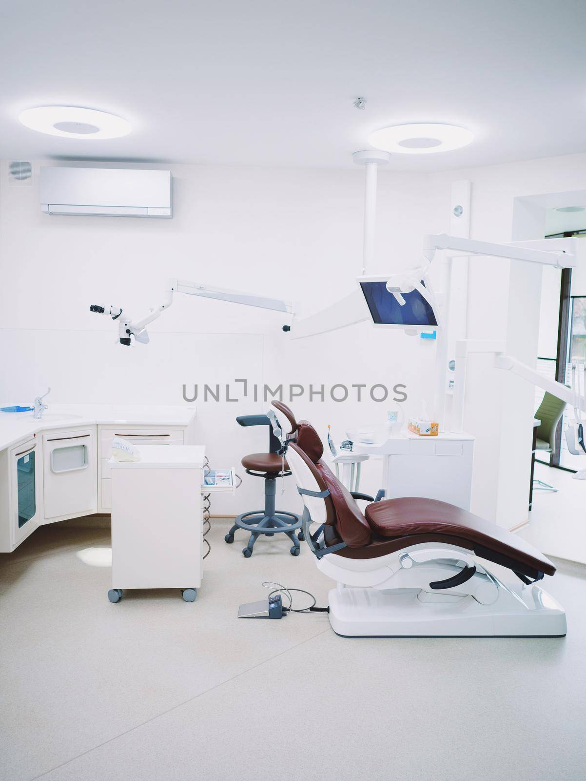Modern dental office. Brown leather chair and other accessories used by dentists in white medic light by kristina_kokhanova