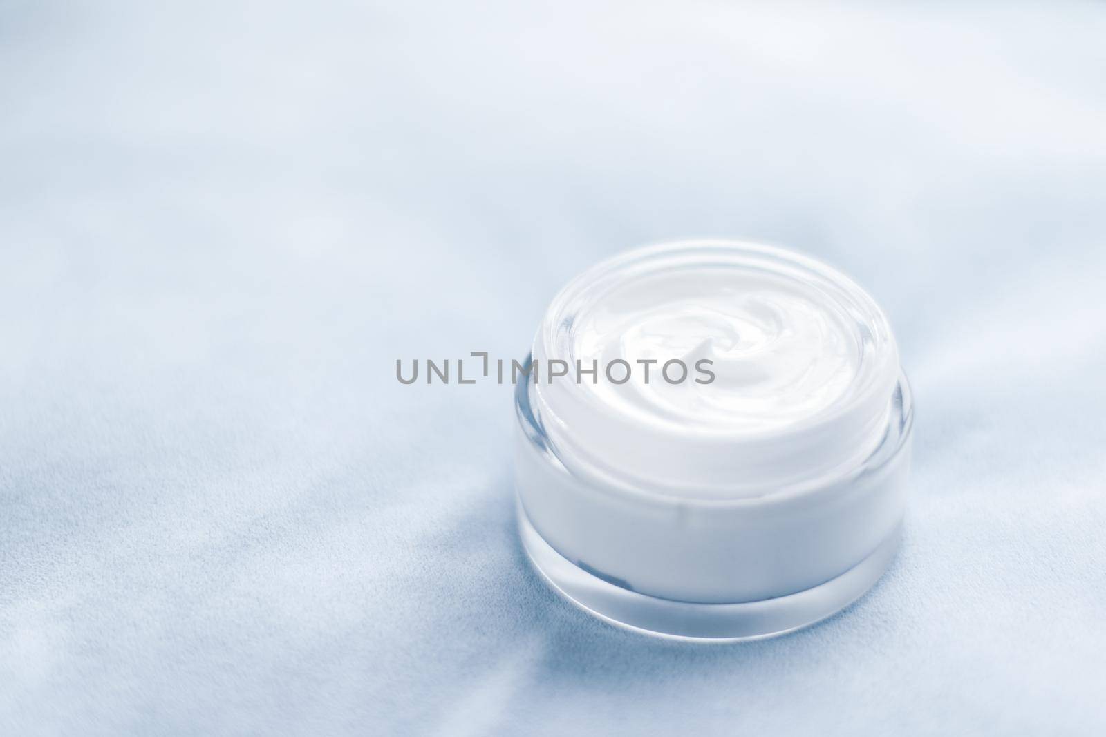 Beauty, anti-age cosmetics and skincare concept - Luxury face cream jar on blue silk