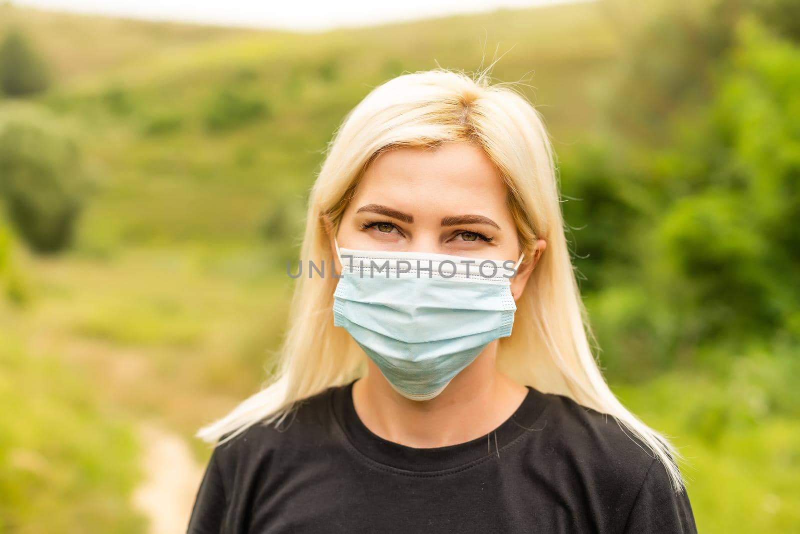 Closeup photo of young beautiful woman in reusable virus protective mask on face against coronavirus. by Andelov13