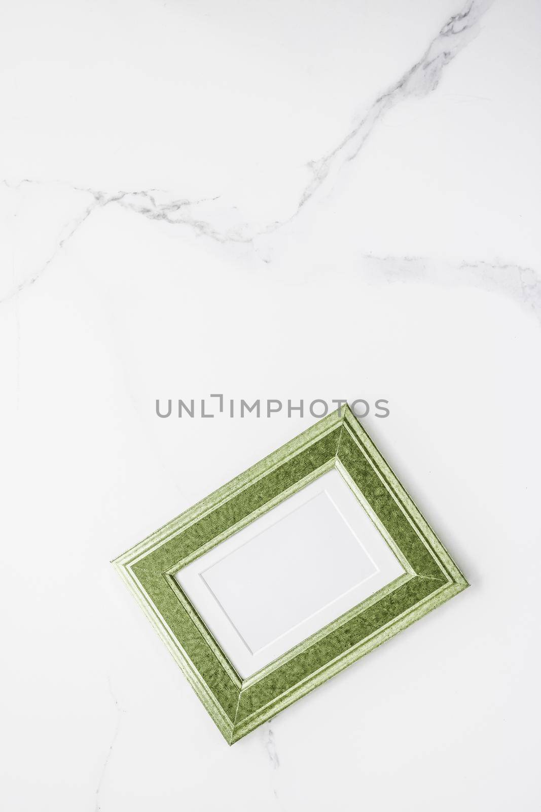 Green photo frame on marble, flatlay by Anneleven