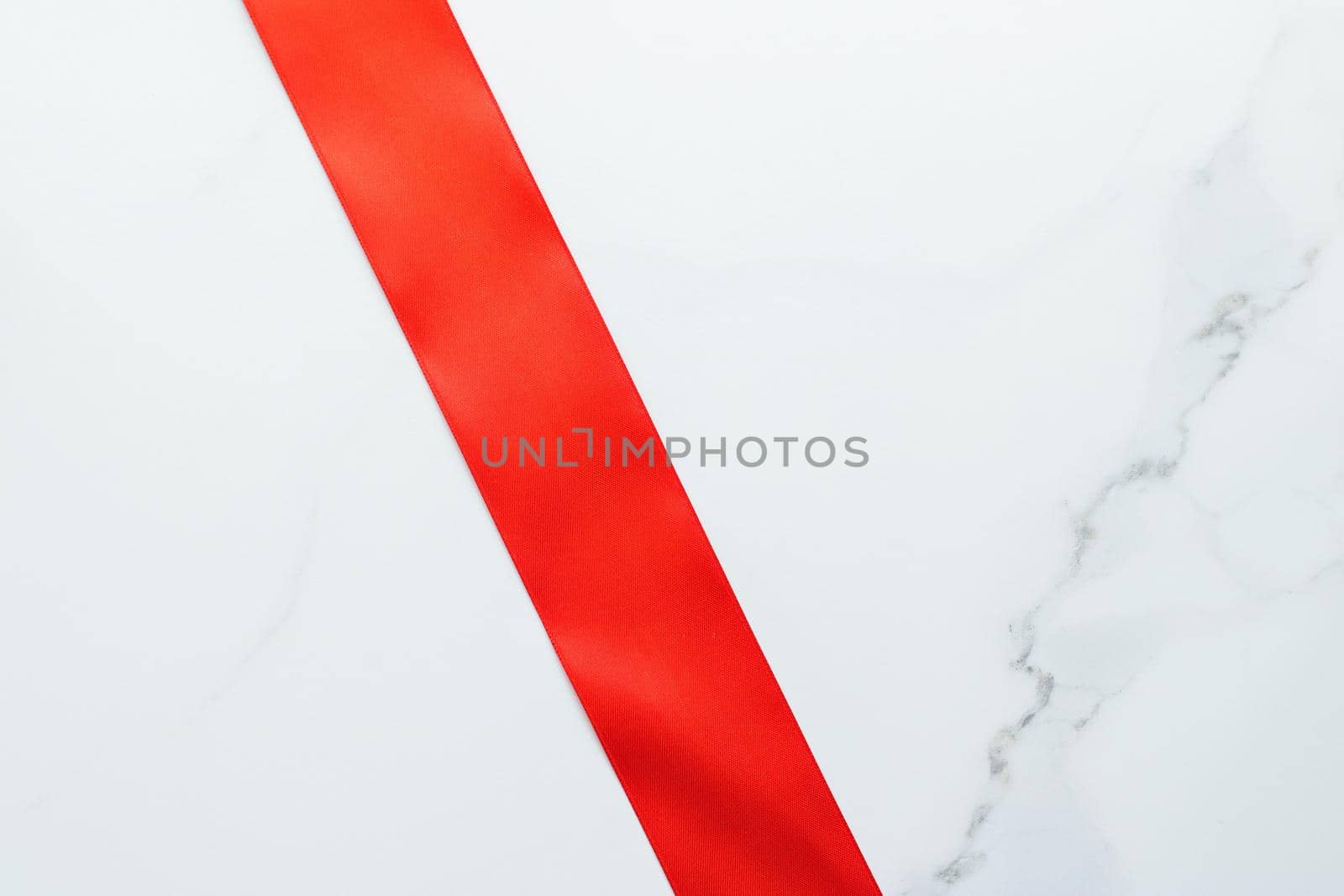 Red silk ribbon on marble, top view by Anneleven