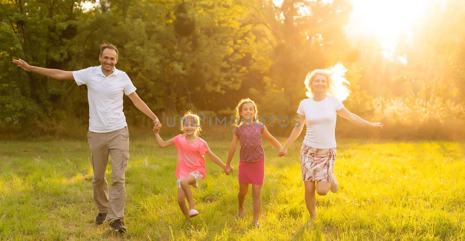 Happy family enjoying life together at meadow outdoor. by Andelov13