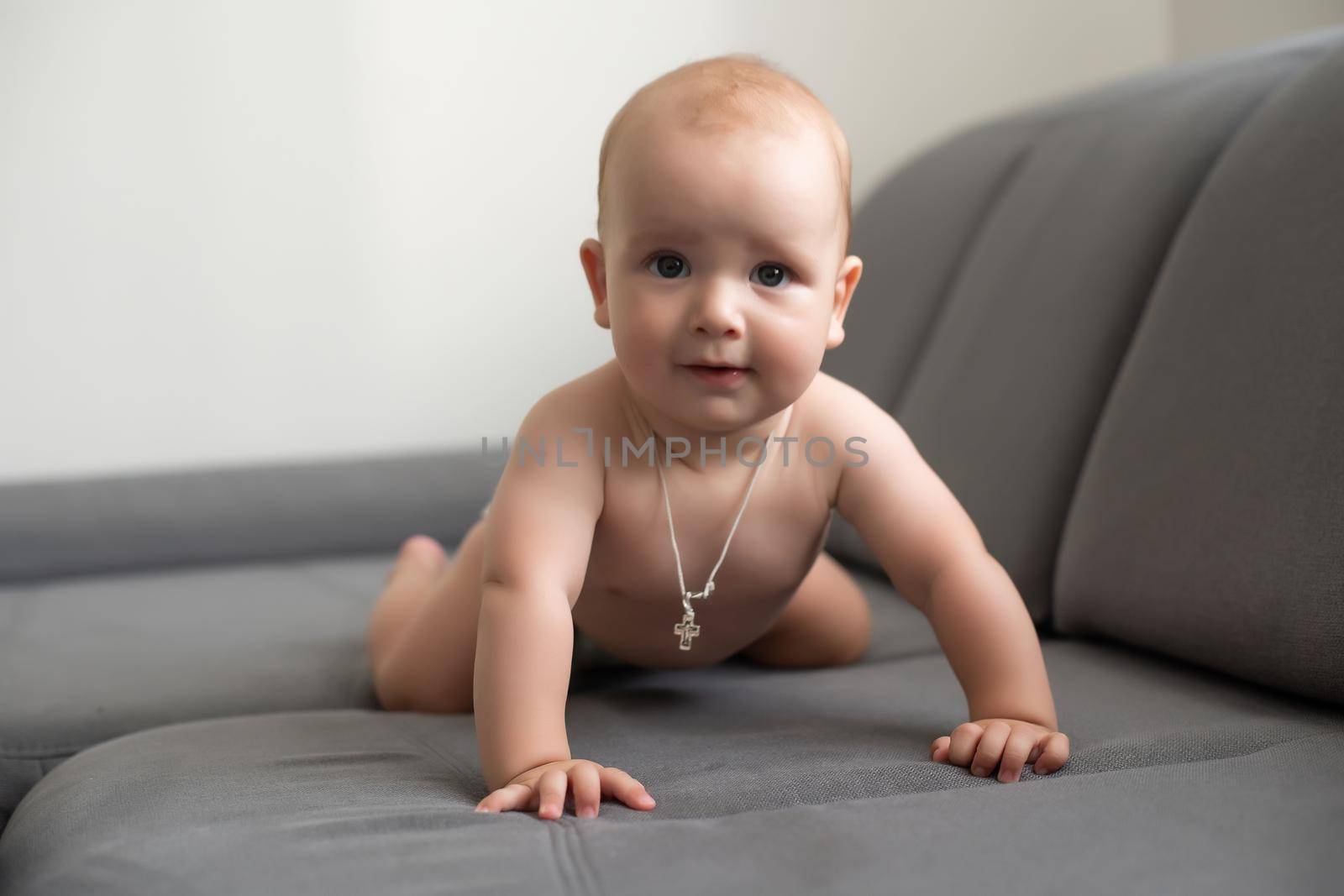 Six month boy sits on the white background.
