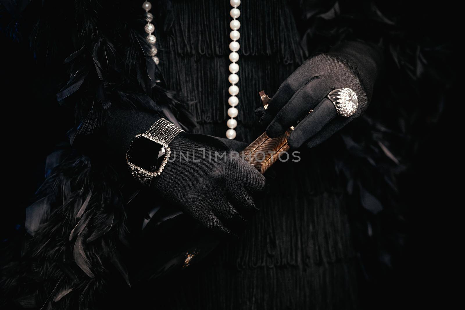 Close up bottle of champagne in hands of flapper woman wearing in style of Roaring Gatsby twenties. Drinking alcohol, celebrating, vintage, retro party, fashion, concept. High quality photo