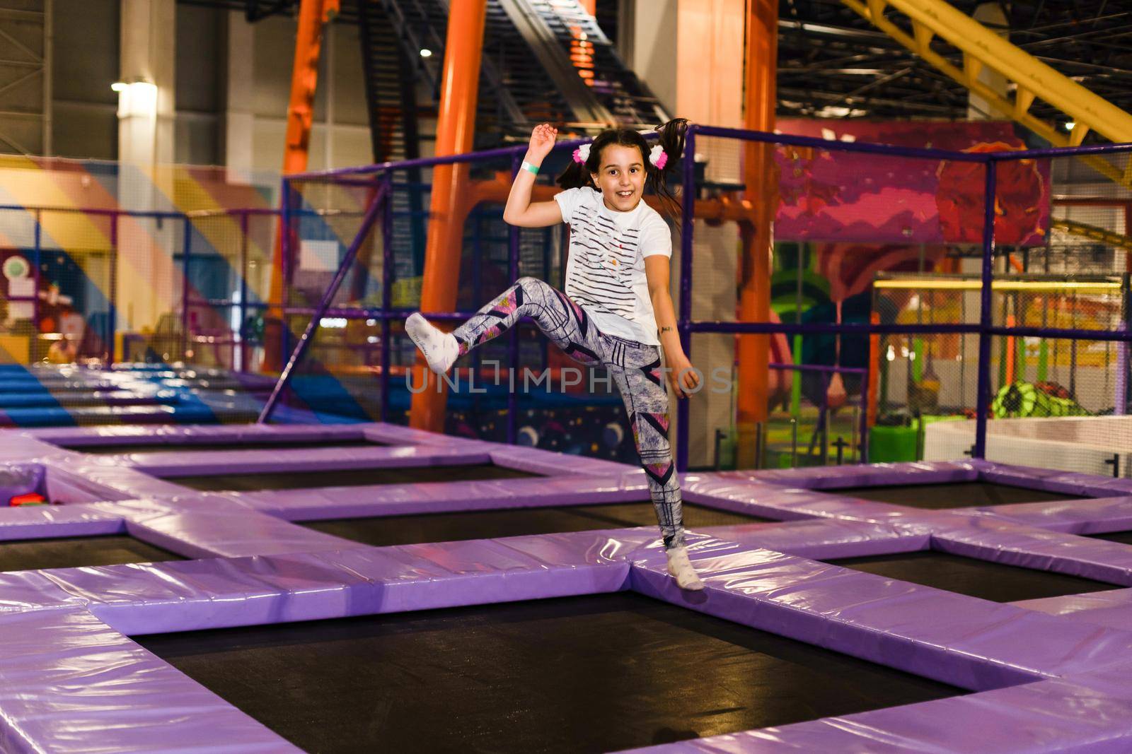 Positive funny girl in casual clothes jumping and smiling.