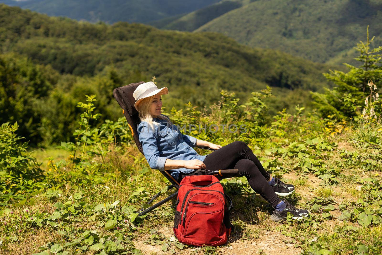 a woman rests after a hike in the mountains by Andelov13