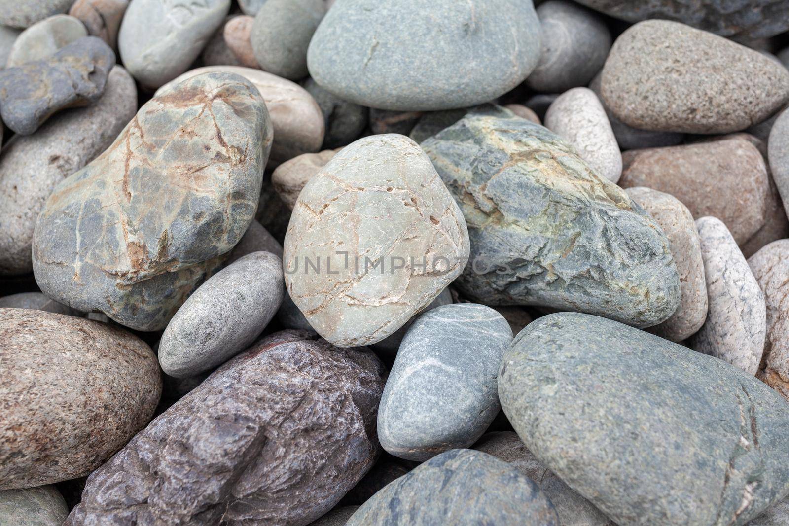 Large stones of different shapes on the riverbank close-up. by AnatoliiFoto