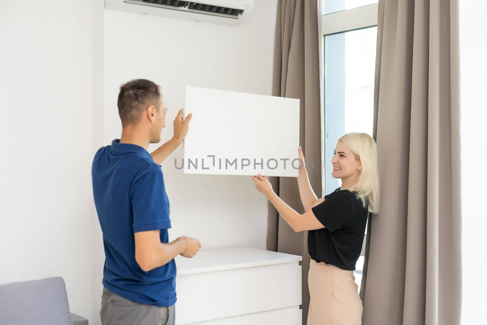 stylish couple holding a photo canvas.