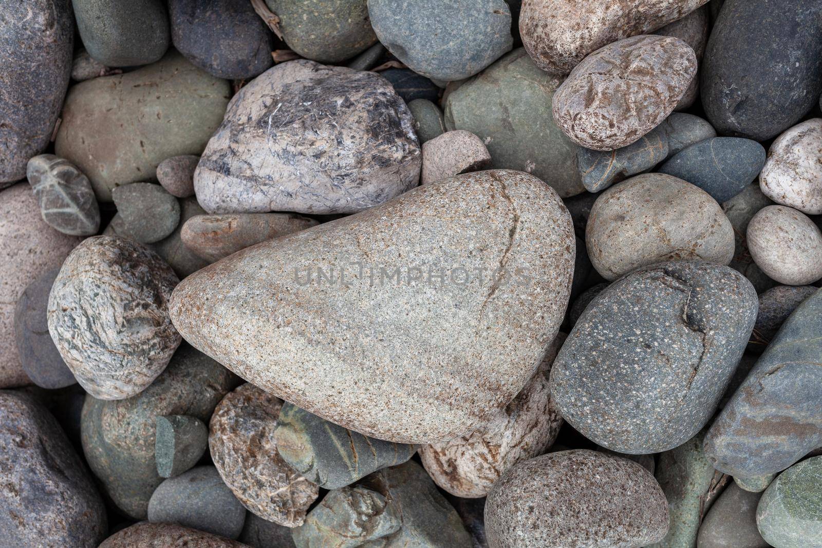 Large stones of different shapes on the riverbank close-up. by AnatoliiFoto