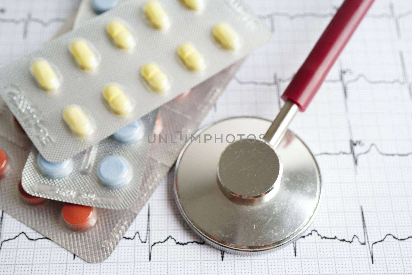 Stethoscope on electrocardiogram (ECG) with drug, heart wave, heart attack, cardiogram report.