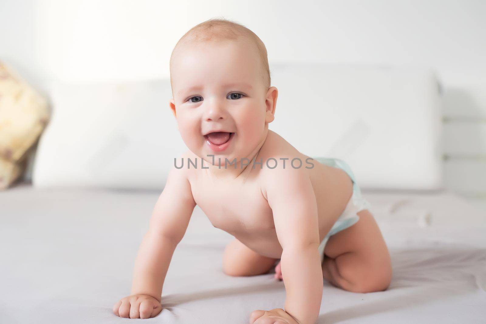 Six month boy sits on the white background.