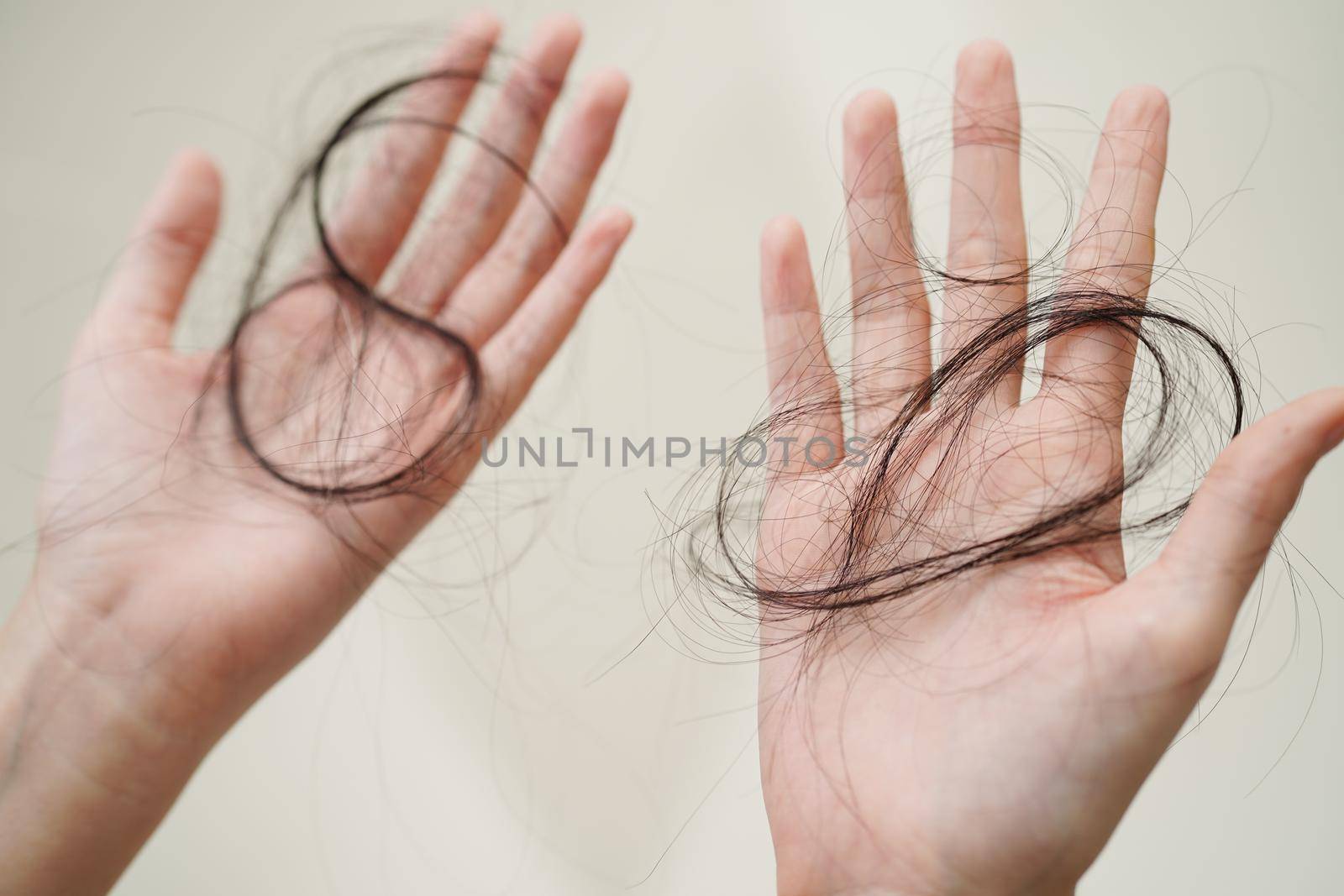 Asian woman have problem with long hair loss attach in her hand.