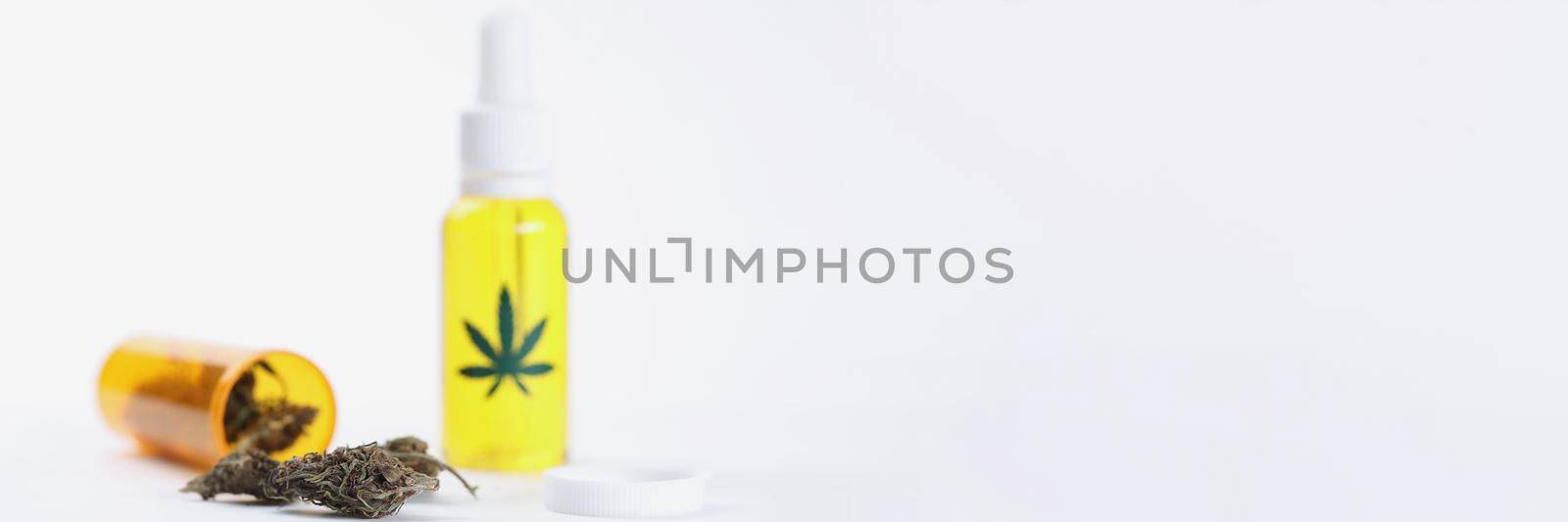 Closeup of marijuana oil in bottles and dried hemp leaves on white background by kuprevich