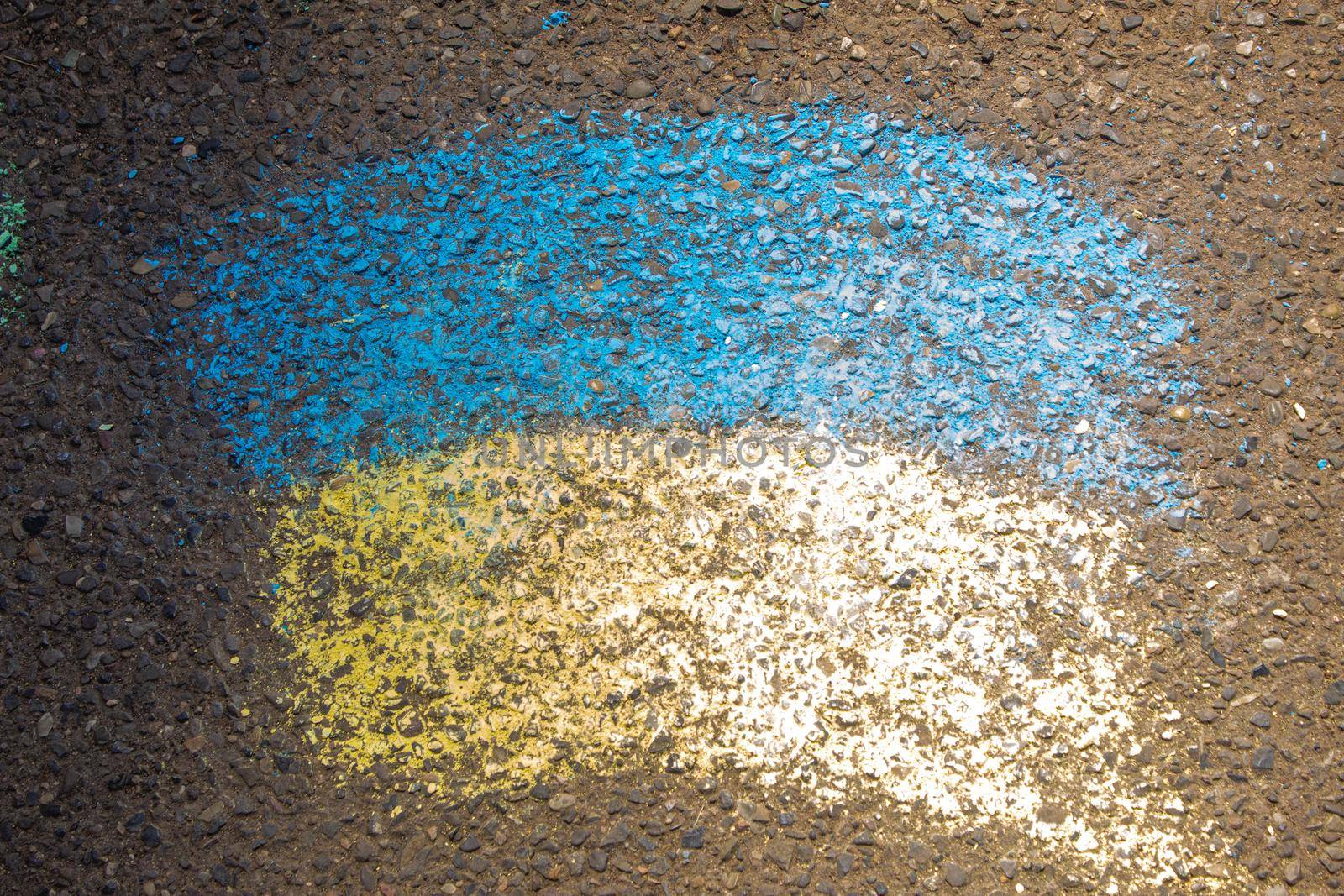 Children paint a rainbow on the asphalt. Selective focus. Kids.