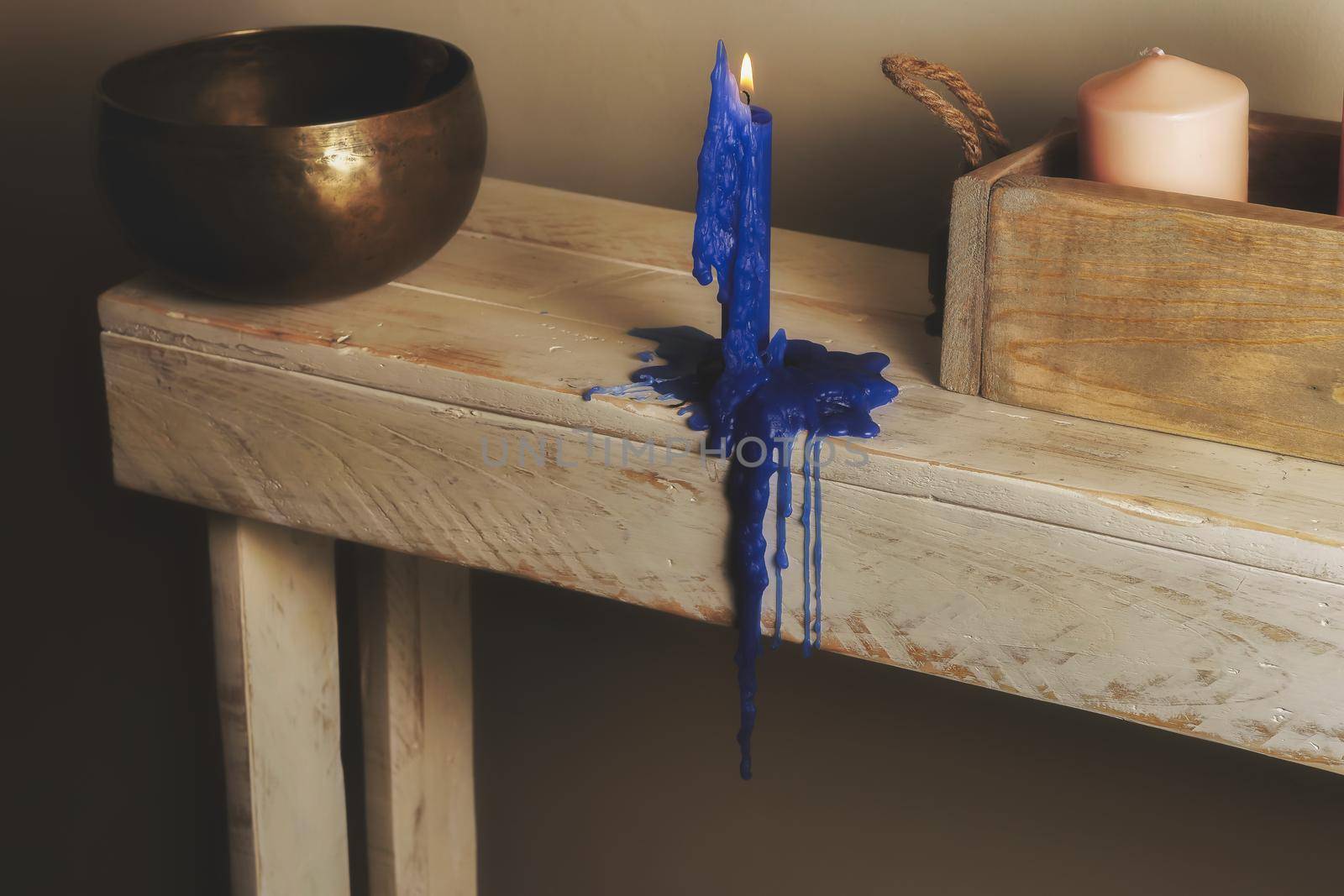 lighted blue candle, Tibetan bowl and wooden tray with candles on wooden table by joseantona