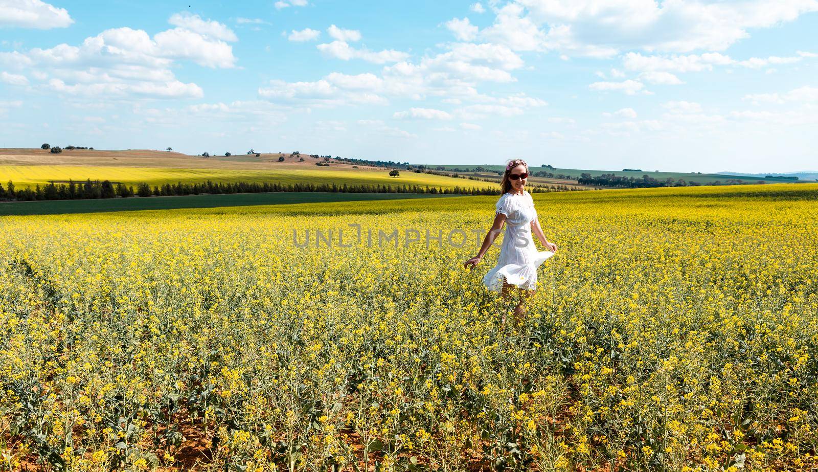 Woman frolicking in a field of flowers in spring by lovleah
