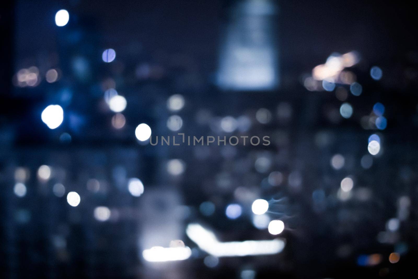 Blurry metropolitan district - night life, abstract background and modern dark tones concept. Big city comes alive at night