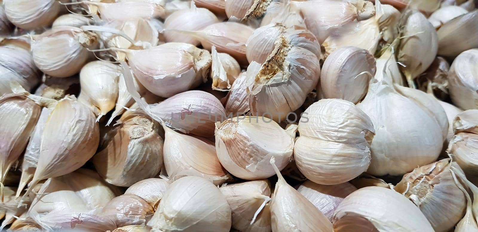Garlic bulbs on black background, close-up. Organic garlic top view. Food background. Selective focus.