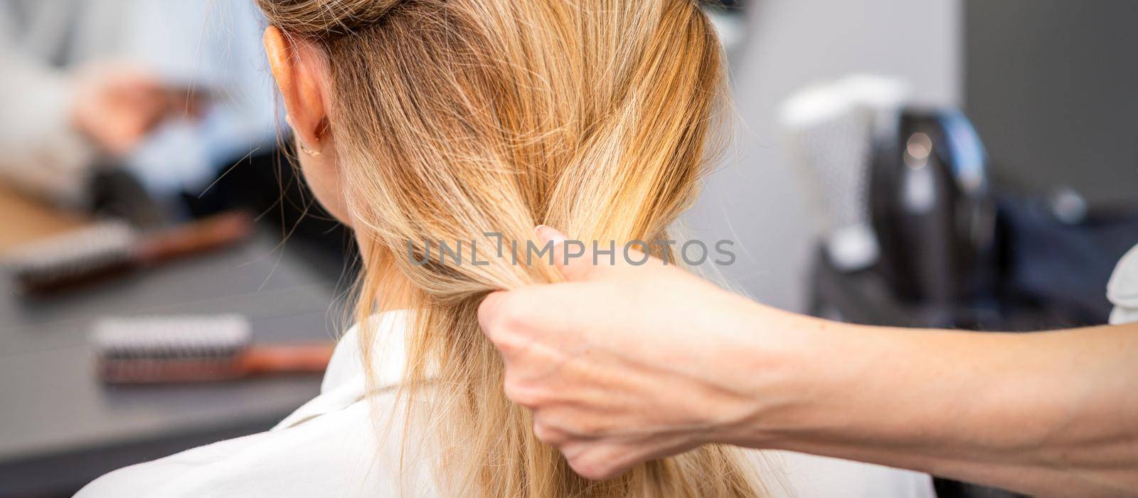 Hairdresser styling hair of woman by okskukuruza