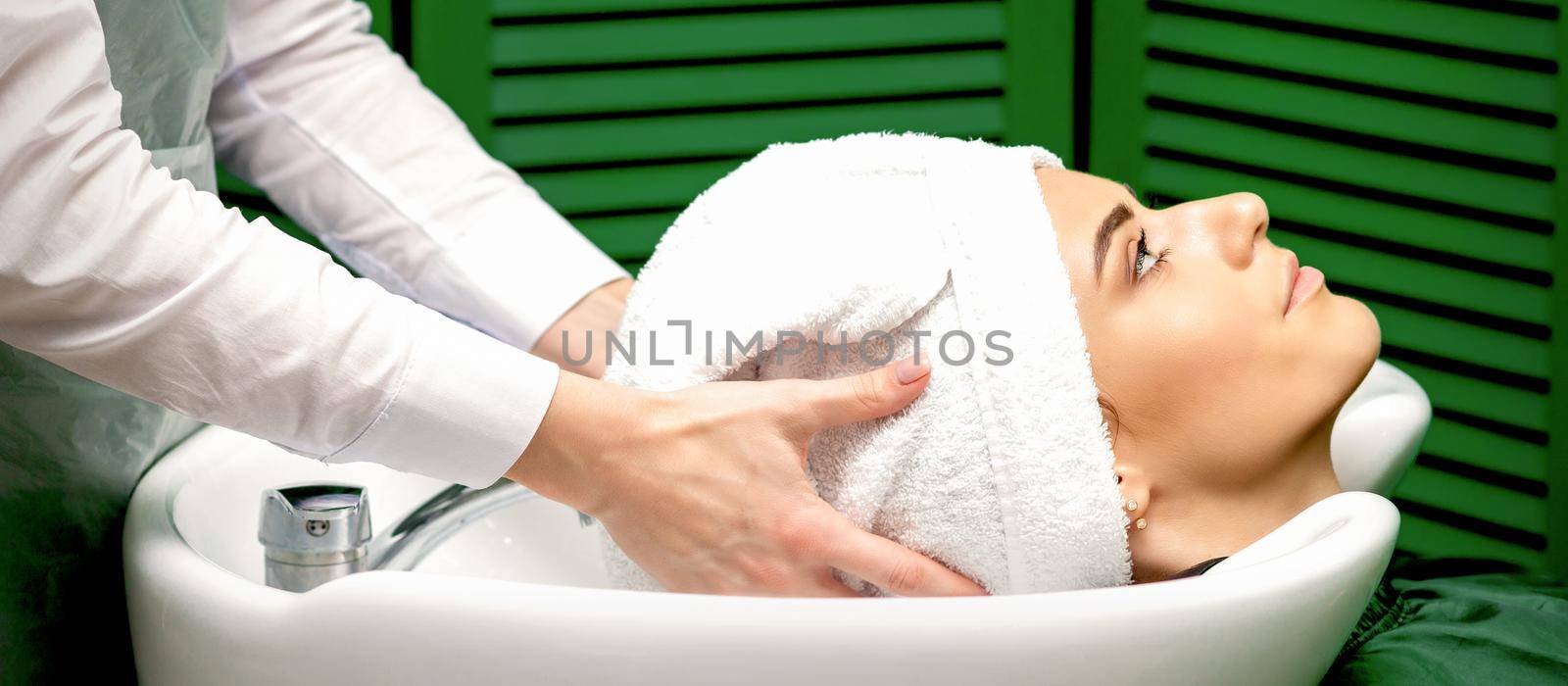 A female hairdresser dries the client hair by okskukuruza