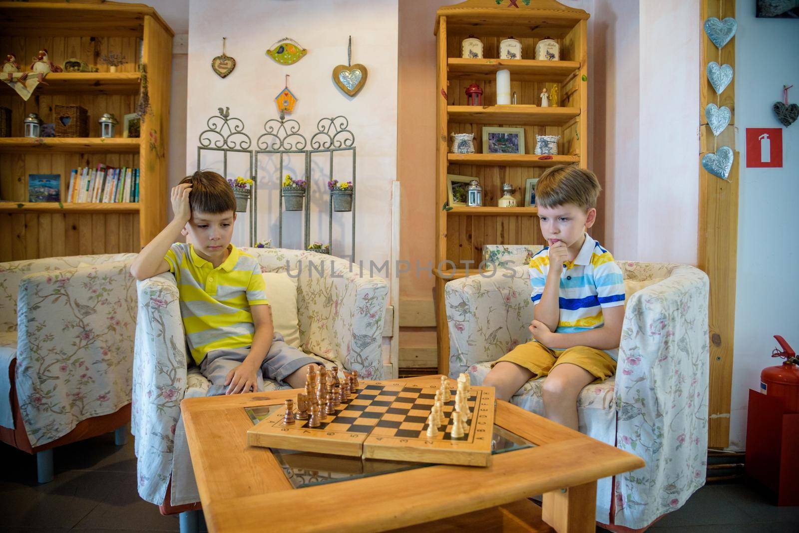 Vivid emotions during the game of chess. two young chess players inside hotel lobby. Tournament chess competition concept.