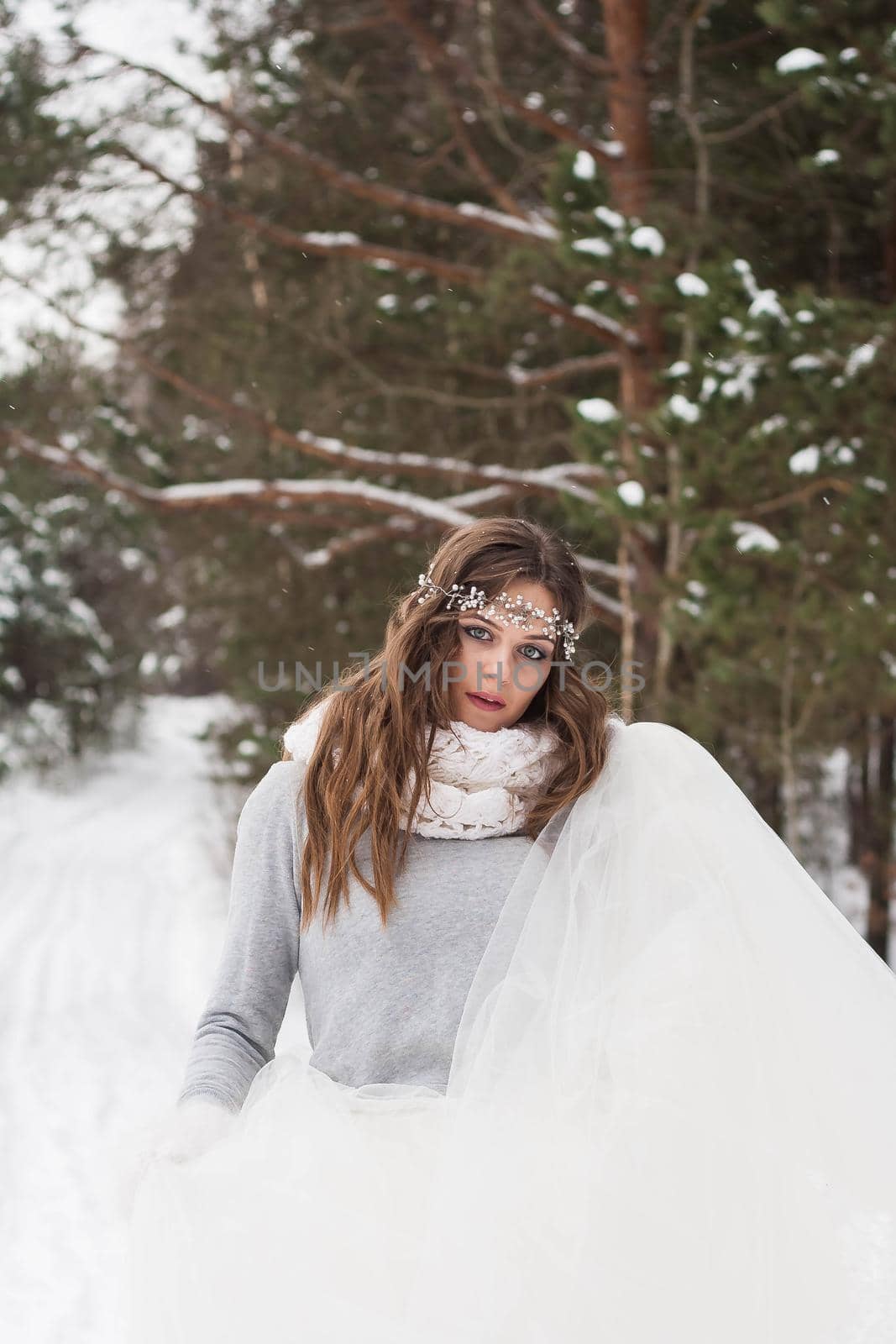 Beautiful bride in a white dress with a bouquet in a snow-covered winter forest. Portrait of the bride in nature by Annu1tochka