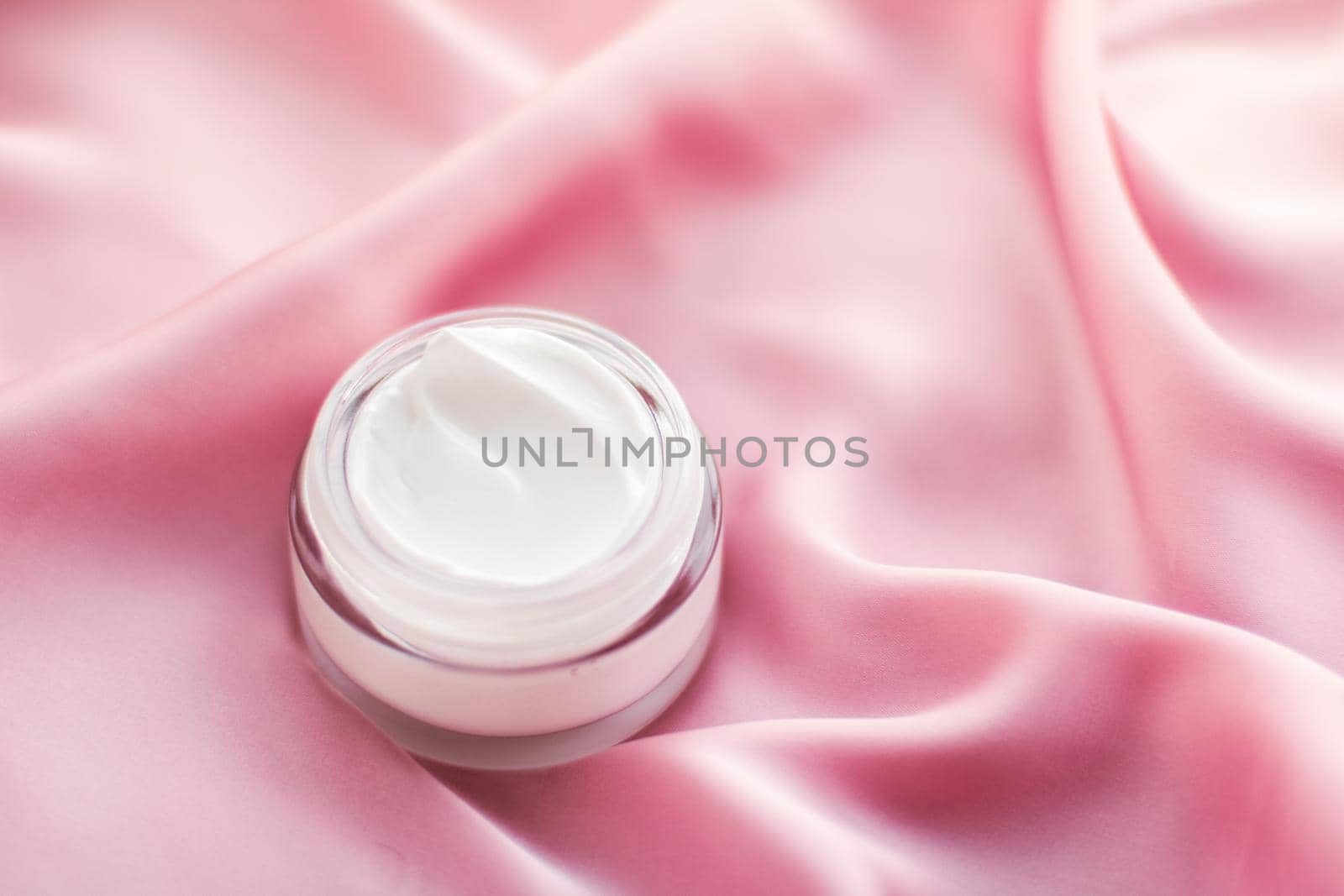 Beauty, anti-age cosmetics and skincare concept - Luxury face cream jar on a soft pink silk