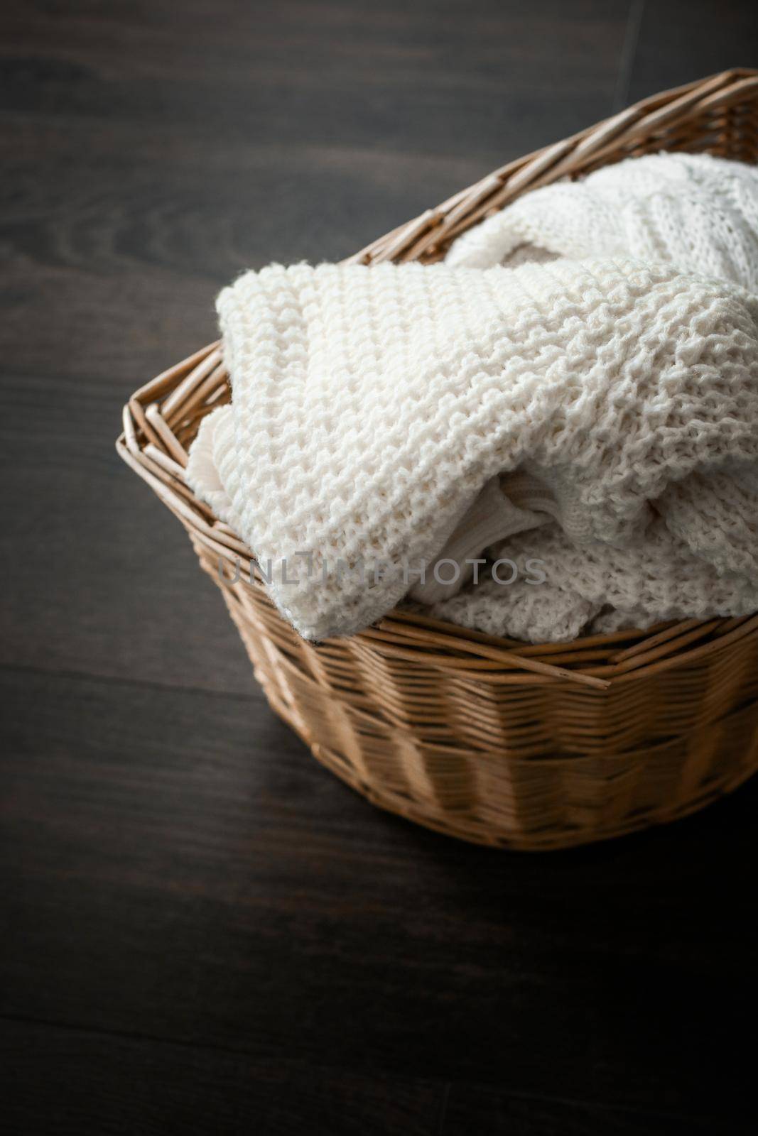 Knitted winter clothes in a basket by Anneleven