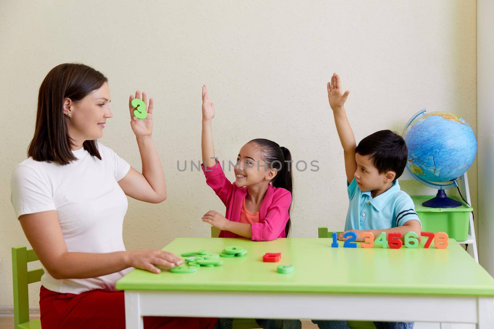 Children practice correct pronunciation with female speech therapist