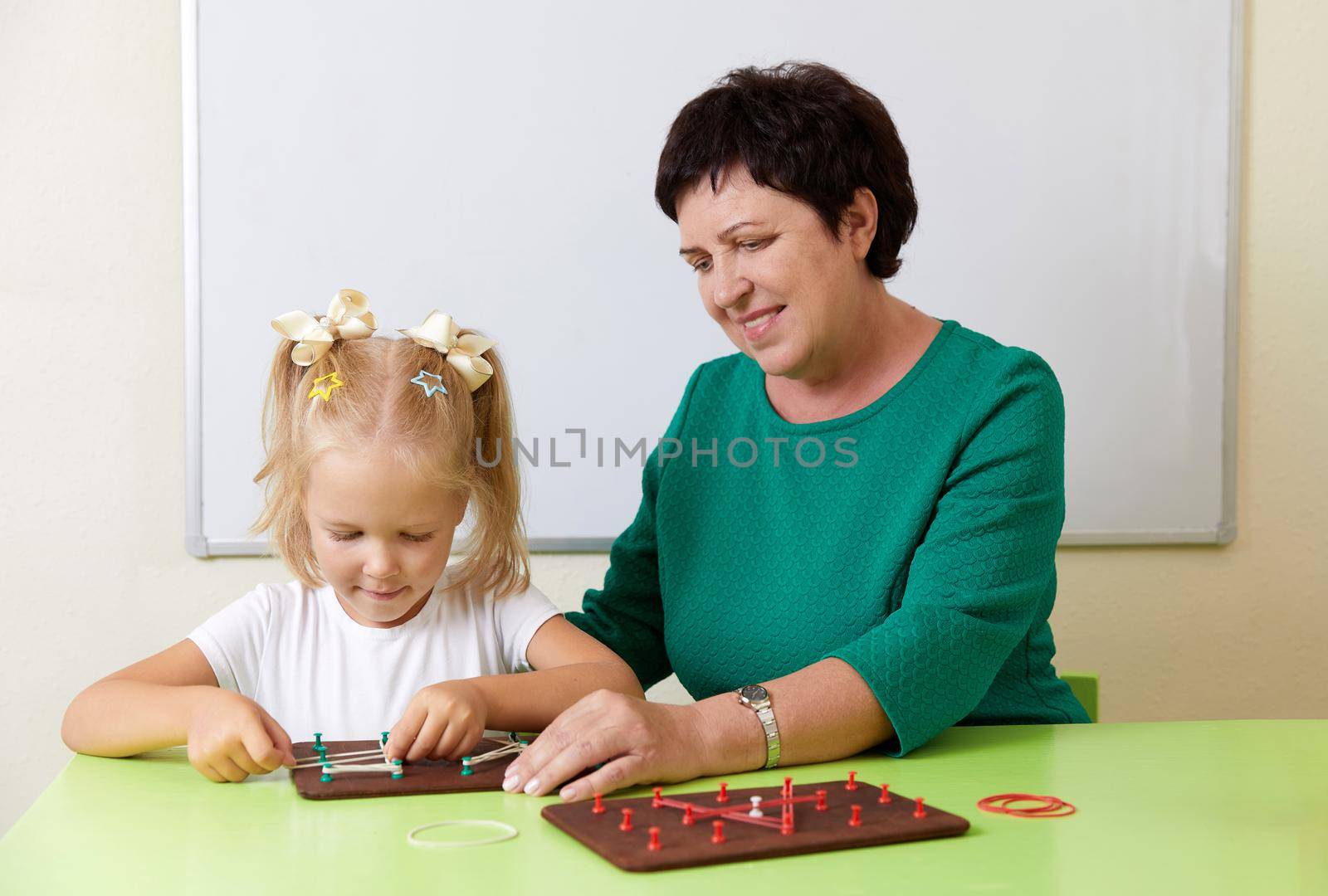 woman teaches child the alphabet. Development of fine motor skills