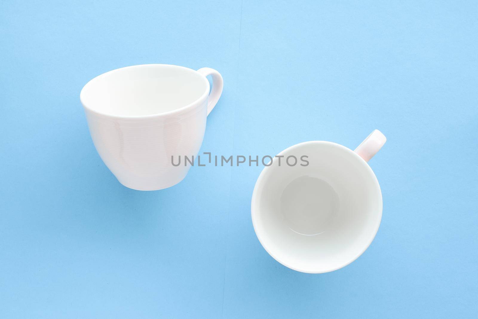 Kitchen, dishware and drinks concept - Empty cup and saucer on blue background, flatlay