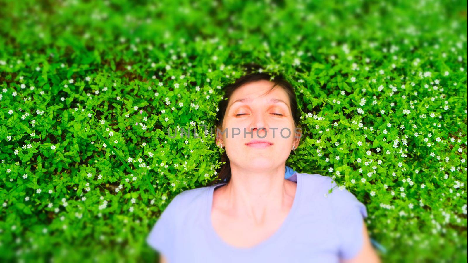 top view portrait of a pretty young woman relaxing on a grass by igor010