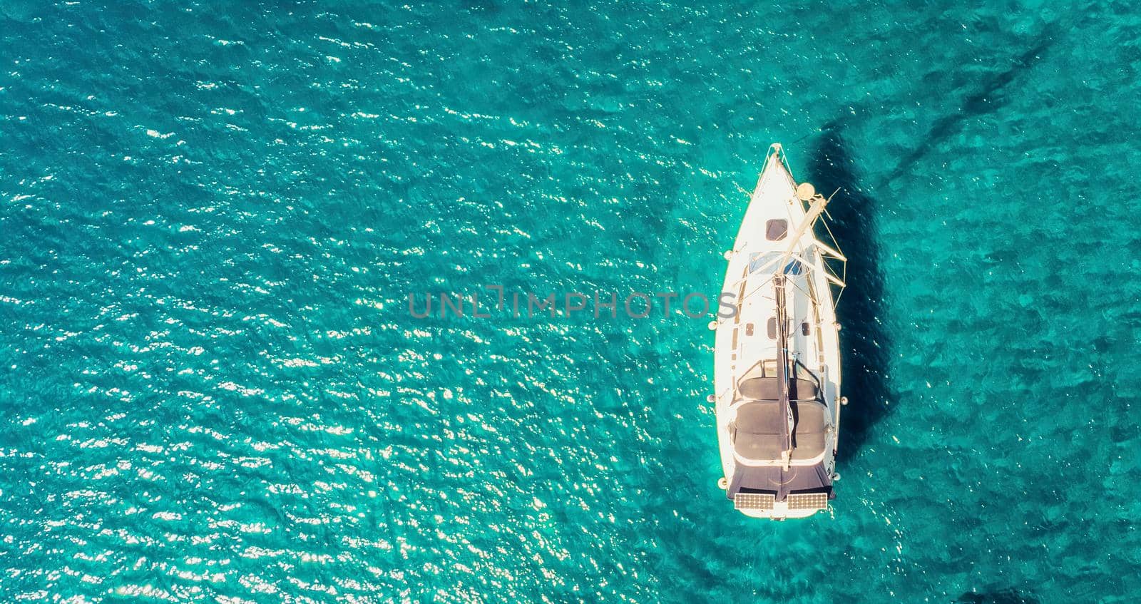 Boat sail floats near the shore. Luxury Lifestyle. Travel on sailboat at sea with clear water. Calm place by igor010