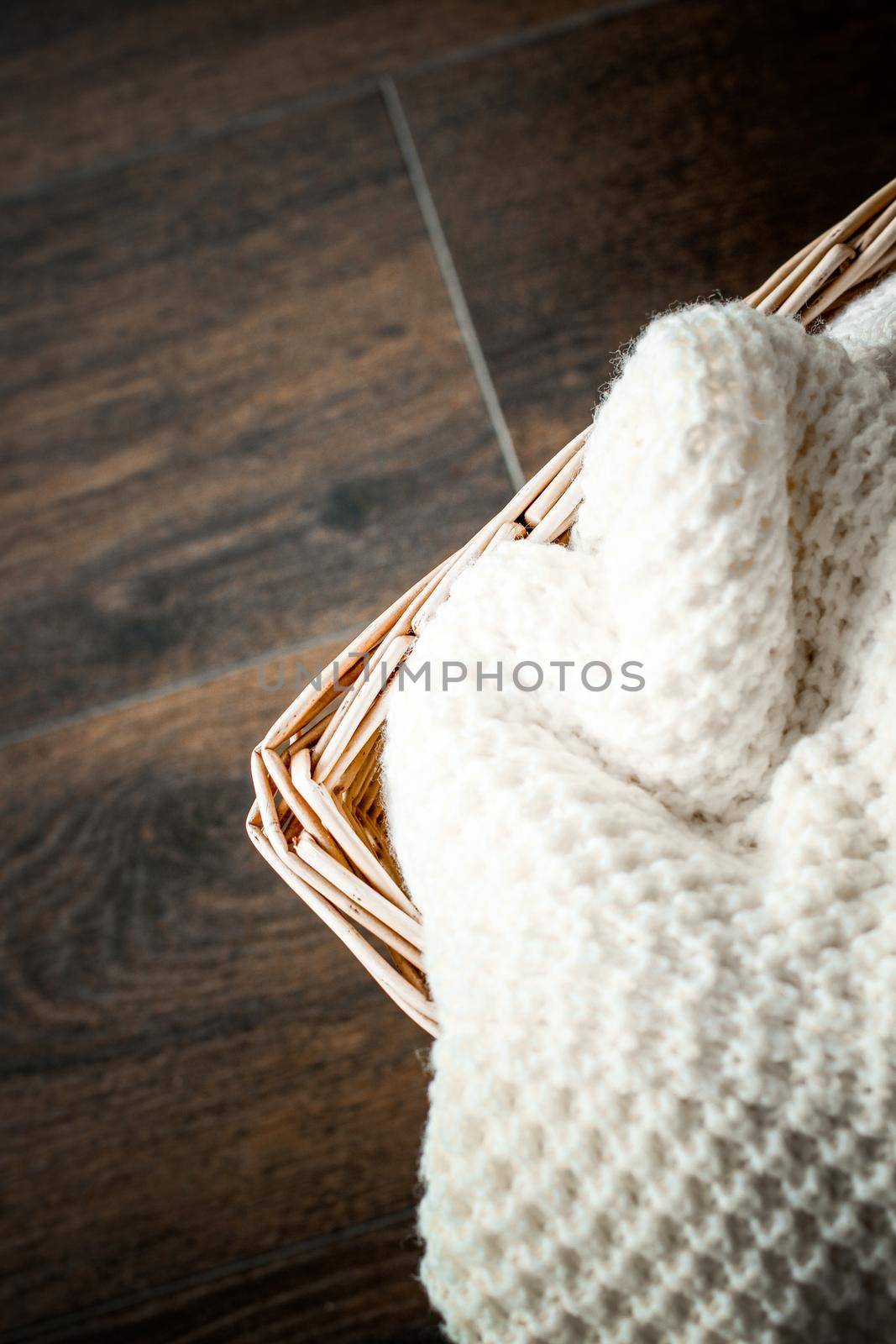 Knitted winter clothes in a basket by Anneleven