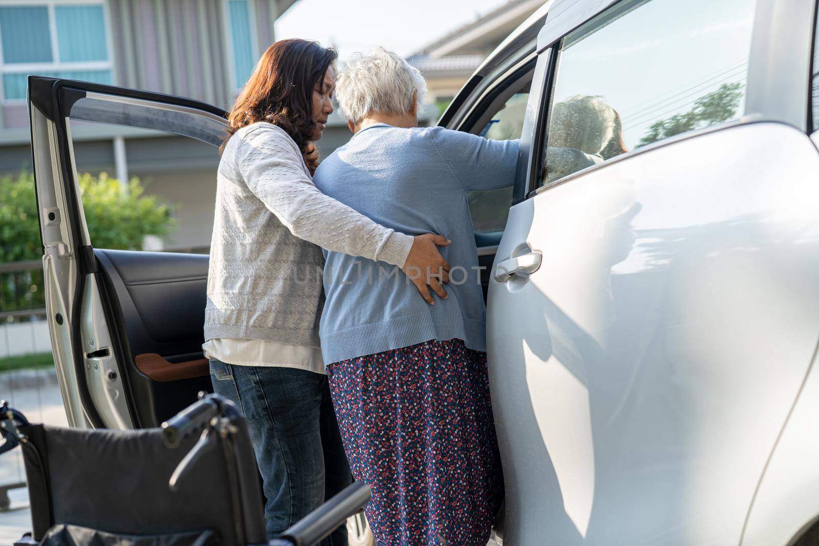 Caregiver help Asian senior or elderly old lady woman patient get to her car, healthy strong medical concept.