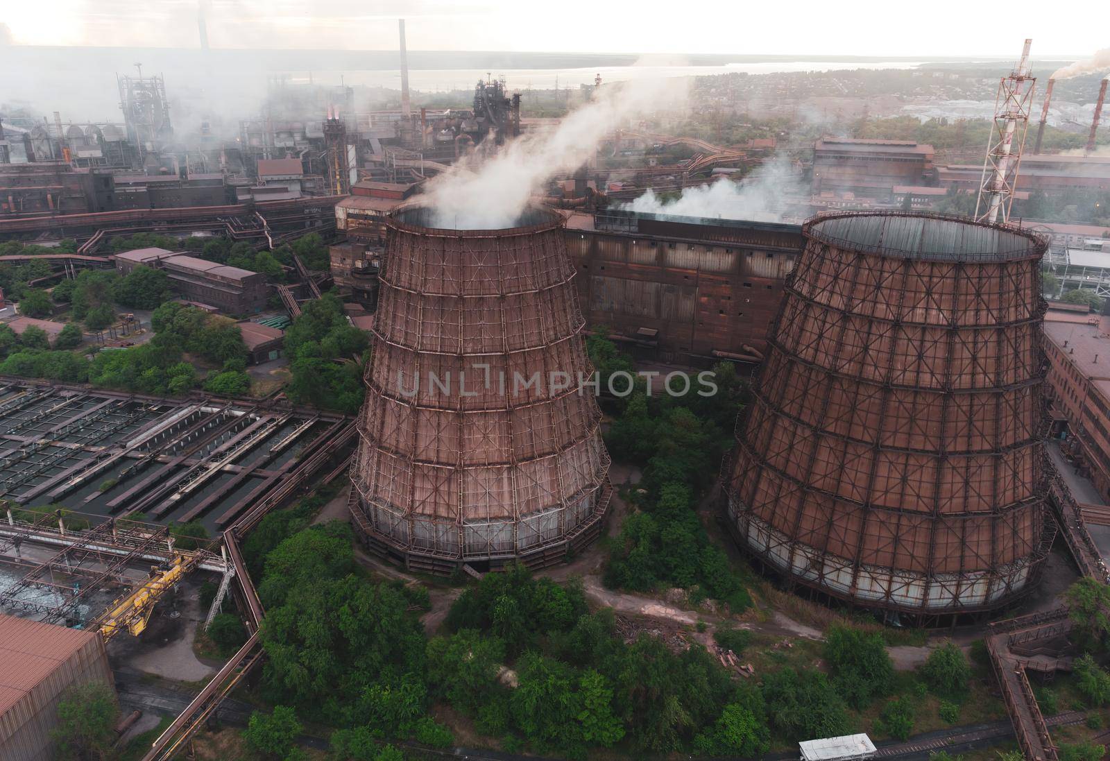 Industrial landscape at the sunset, aerial view. Smoke coming out from factory chimneys. steelworks Industrial buildings. Environmental disaster. Harmful emissions into. Exhaust gases. download photo